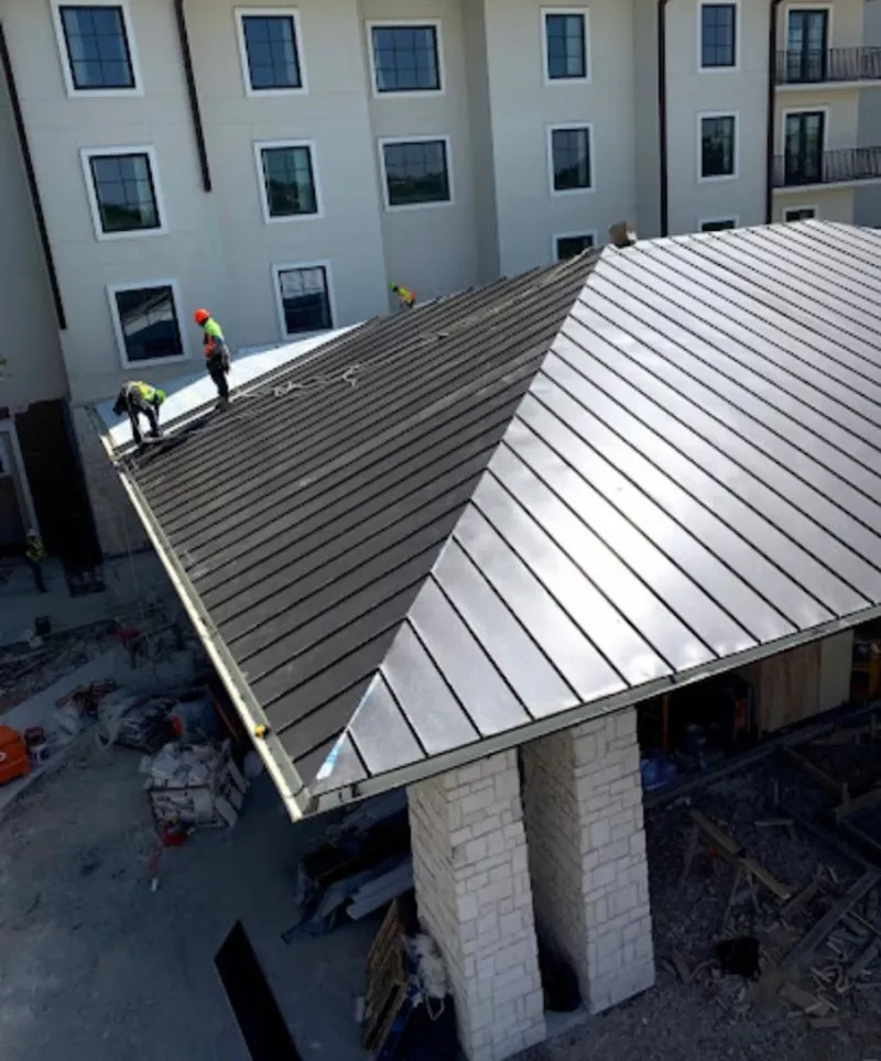 Crew installing standing seam metal roof panels on a commercial project in McKinleyville